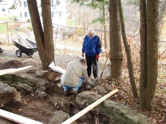 Foundation stones are laid in the pathway to ensure that the new bridge will remain stable and level.