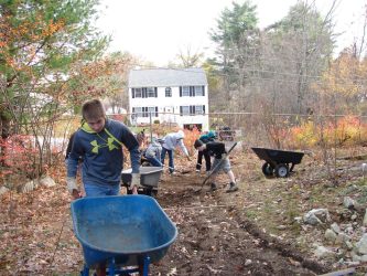 Boyscouts from Troop 21 remove the rocky dirt and soil to be replaced with RAP (recycled asphalt) so that no new plants will grow in the spring.