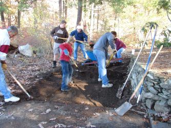 Boyscouts from Troop 21 remove the rocky dirt and soil to be replaced with RAP (recycled asphalt) so that no new plants will grow in the spring.